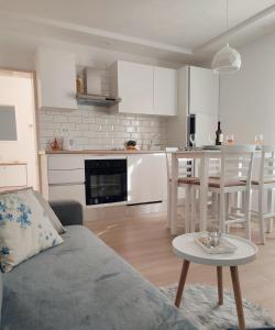 a living room with a couch and a table and a kitchen at Apartment Making memories in Pučišća