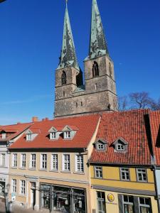 un edificio con techo rojo y dos torres en Hotel garni "Alter Fritz", en Quedlinburg