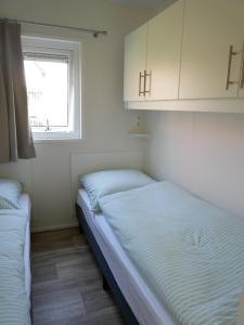 two beds in a small room with a window at Tiny Ferienhaus Kelze in Hofgeismar