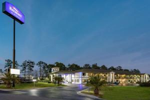 a hotel building with a sign in front of it at Baymont by Wyndham Midway Tallahassee in Midway