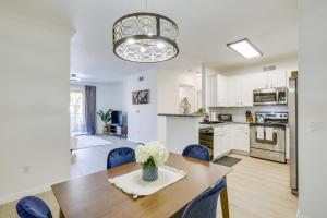 a kitchen and dining room with a wooden table and blue chairs at Modern Pet-Friendly San Diego Vacation Rental in San Diego