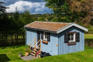 a blue shed with two windows and a staircase at Tiny Chalet 2 in Clausthal-Zellerfeld