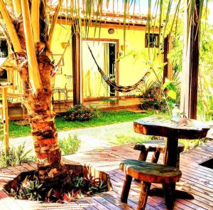 a wooden table and bench next to a tree at Home suíte taipu in Marau