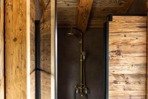 y baño con ducha y paredes de madera. en Tiny Chalet en Clausthal-Zellerfeld