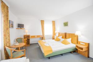 Habitación de hotel con cama y escritorio en Hotel garni Zwickau-Mosel en Mülsen