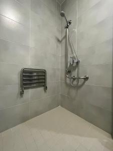 a shower in a bathroom with a tile wall at Complejo Leo 24H in Monesterio