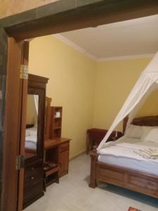 a bedroom with two beds and a mirror at Khailash Warung and Home Stay in Sidemen
