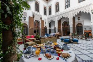 a table with food on it in a courtyard at Riad Semlalia in Fès