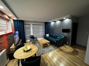 a living room with a blue couch and a table at Apartament VIP-2 in Reda