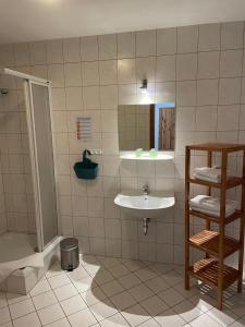 y baño con lavabo, ducha y bañera. en Landgasthof und Landpension Hohenkirchen, 