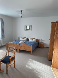 1 dormitorio con 1 cama, 1 mesa y 1 silla en Landgasthof und Landpension Hohenkirchen, 