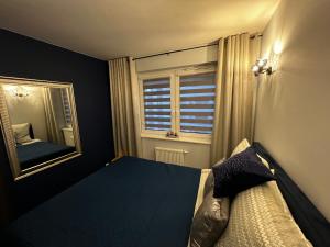 a bedroom with a bed and a mirror and a window at Apartament VIP-2 in Reda