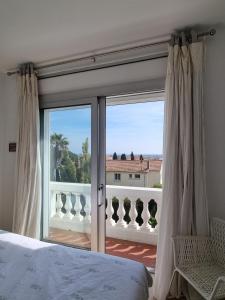 a bedroom with a bed and a view of a balcony at Villa Marguerite in Hyères