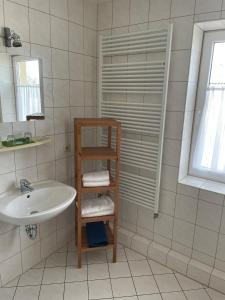 baño con lavabo y estante con toallas en Landgasthof und Landpension Hohenkirchen, 