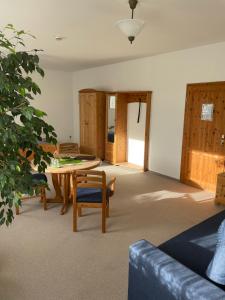 a living room with a wooden table and chairs at Landgasthof und Landpension Hohenkirchen in Hohenkirchen