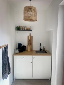 a kitchen with a counter with a sink and a light at Hotel Der Drahtesel in Bramberg am Wildkogel