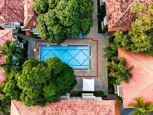 una vista aérea de una piscina con árboles y edificios en Radisson Goa Candolim, en Candolim