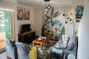 a living room with two blue chairs and a tv at La Perle de Caniço by LovelyStay in Santa Cruz