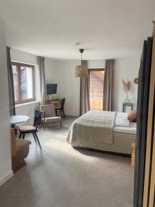 a bedroom with a bed and a table and chairs at Hotel Der Drahtesel in Bramberg am Wildkogel