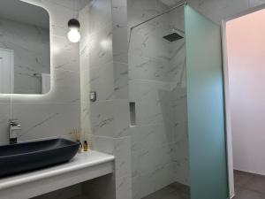 a bathroom with a black sink and a mirror at SUNSENSES Villa in Angairiá