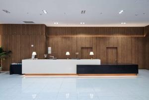 a lobby with a reception desk and wooden walls at Ramada Encore by Wyndham CheonAn in Cheonan