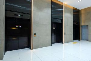 a row of elevator doors in a building at Ramada Encore by Wyndham CheonAn in Cheonan