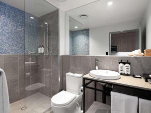 a bathroom with a toilet and a sink and a shower at The Sebel Brisbane Margate Beach in Redcliffe