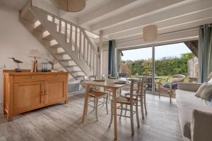 アルゾンにあるMaison pour 5 à quelques pas de la plage !のリビングルーム(テーブル、椅子、階段付)