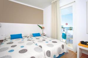 a bedroom with a large bed with a view of the ocean at Apartamentos Bellamar in Port de Pollensa