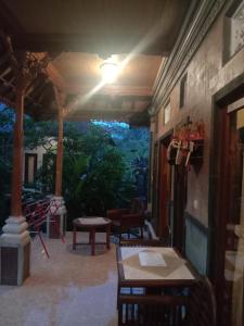 a patio with a table and chairs and a light at Khailash Warung and Home Stay in Sidemen