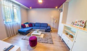 a living room with a blue couch and a table at Apartment Focus in Mostar