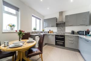 a kitchen with a wooden table and chairs in it at Birkdale Southport Boutique Apartment sleeps 5 in Southport