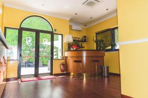 a kitchen with yellow walls and a bar with stools at CANELLA HOTEL in Rome