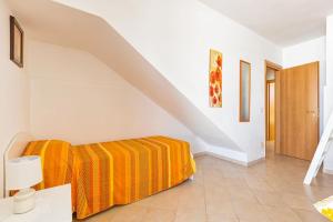 um quarto branco com uma cama com um cobertor laranja em Salentoandmore - Villetta Lecci em Salve