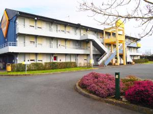 a large building with a staircase in front of it at Premiere Classe Saumur in Saumur