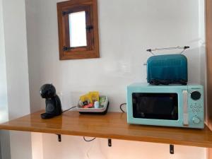 Un four micro-ondes est installé au-dessus d'une table en bois. dans l'établissement La alcoba de La Catedral, Apartamento 2-4 pax 3º piso, à Cuenca