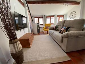 - un salon avec un canapé et une télévision dans l'établissement La alcoba de La Catedral, Apartamento 2-4 pax 3º piso, à Cuenca