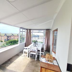 a white room with a table and chairs on a balcony at Dann's Corner in Mossel Bay