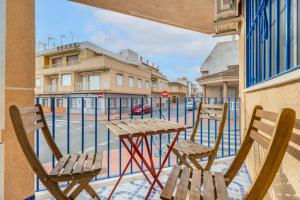 d'une table et de chaises sur un balcon donnant sur une rue. dans l'établissement 040 Apartamento Norra, à Torrevieja