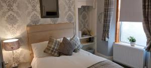 a bedroom with a bed with pillows and a window at Riverbank Guesthouse Inverness in Inverness