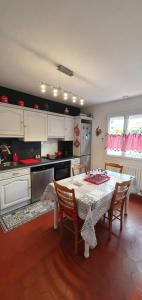 a kitchen with a table and chairs and a kitchen with white cabinets at ENTRE Terre ET Mer in Saint-Aubin-le-Cauf