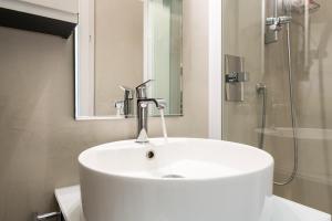 un lavandino bianco in bagno con doccia di Maison Marconi a Bologna