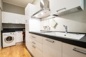 a kitchen with a sink and a washing machine at Maison Marconi in Bologna