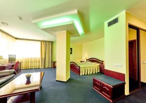 ein Hotelzimmer mit einem Bett und einem Sofa in der Unterkunft Hotel Sfinksas in Kaunas