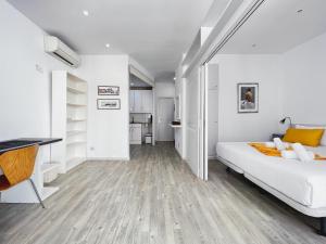 Habitación blanca con cama y escritorio en Stay U-nique Apartments GranDeGracia, en Barcelona