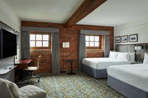 a hotel room with two beds and a flat screen tv at Manchester Marriott Victoria & Albert Hotel in Manchester