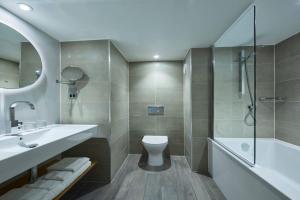 a bathroom with a sink and a toilet and a tub at Manchester Marriott Victoria & Albert Hotel in Manchester