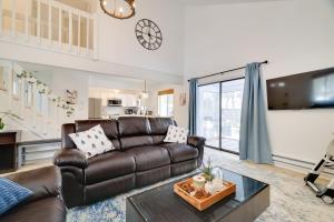 Una sala de estar con un sofá de cuero y una mesa. en Tobyhanna Home with Fire Pit and 3 Community Pools!, en Tobyhanna