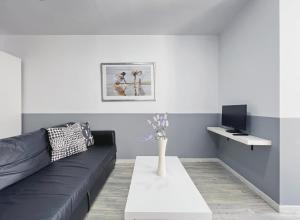 sala de estar con sofá negro y mesa blanca en Stay U-nique Apartments GranDeGracia, en Barcelona