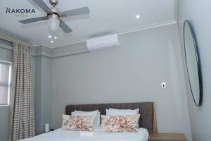 a bedroom with a bed with a ceiling fan at Deluxe 3 Bed Apartment in Polokwane